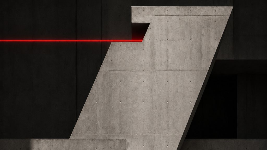 A pale concrete mass folded into a Z against a black hall, one red seam running across the top.